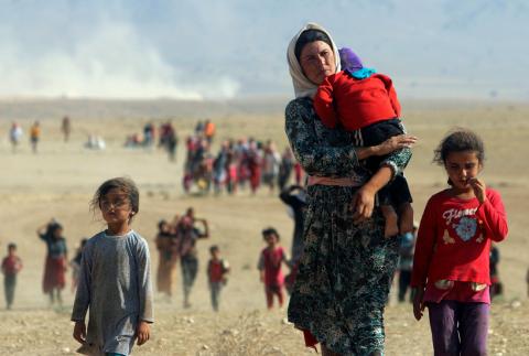 Displaced people from the minority Yazidi sect, fleeing violence from forces loyal to the Islamic State in Sinjar town, walk towards the Syrian border on the outskirts of Sinjar mountain near the Syrian border town of Elierbeh of Al-Hasakah Governorate in this August 11, 2014. PHOTO BY REUTERS/Rodi Said