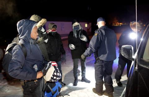 Refugees that walked along railway tracks from the United States to enter Canada are detained by the Royal Canadian Mounted Police at Emerson, Manitoba, Canada, February 26, 2017. PHOTO BY REUTERS/Lyle Stafford