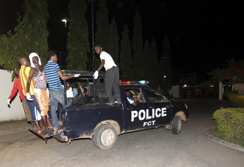 Volunteer rescue workers travel on a police van used to evacuate victims after a bombing to Asokoro General Hospital in Abuja