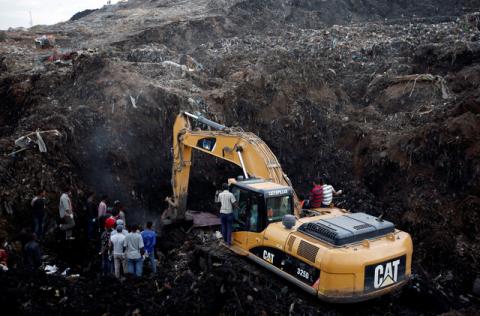 Rescue workers watch as excavators dig into a pile of garbage in search of missing people following a landslide when a mound of trash collapsed on an informal settlement at the Koshe garbage dump in Ethiopia's capital Addis Ababa. PHOTO BY REUTERS/Tiksa Negeri