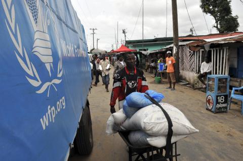 A resident of West Point neighborhood, which has been quarantined following an outbreak of Ebola, pushes a wheelbarrow full of food rations from the United Nations World Food Programme (WFP) in Monrovia