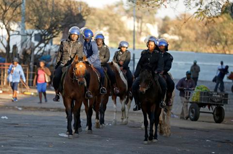 Riot police officers ride horses as they patrol the streets in Bulawayo, Zimbabwe, August 19, 2019. PHOTO BY REUTERS/Philimon Bulawayo