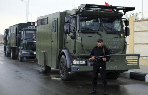 A riot police officer stands guard outside a police academy, where the trial of ousted Egyptian President Mohamed Mursi and members of the Muslim Brotherhood is due to take place, on the outskirts of Cairo