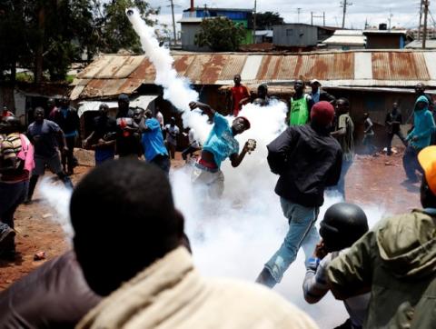 An opposition supporter returns a teargas canister fired by police during clashes in Kibera slum in Nairobi, Kenya, October 26, 2017. PHOTO BY REUTERS/Goran Tomasevic