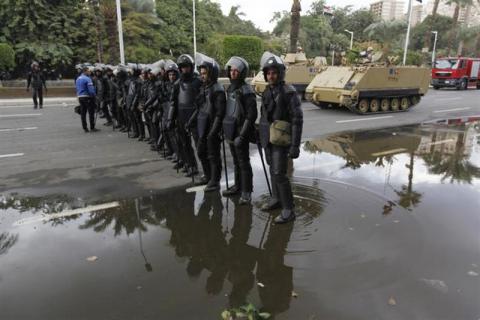 Egyptian security forces and army vehicles hold their positions outside Cairo university during clashes between riot policemen and Cairo University students, who are supporters of the Muslim Brotherhood and ousted Egyptian President Hosni Mubarak