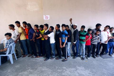 Rohingya men stand in a line at a centre to register for a temporary card issued by the United Nations High Commissioner for Refugees (UNHCR) in Kuala Lumpur, February 27, 2014. PHOTO BY REUTERS/Samsul Said