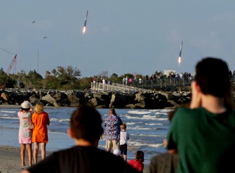 Spectators watch from Jetty Park as booster rocket engines approach landing pads, after a SpaceX Falcon Heavy rocket, carrying the Arabsat 6A communications satellite, lifted off from the Kennedy Space Center in Cape Canaveral , Florida, U.S., April 11, 2019. PHOTO BY REUTERS/Joe Rimkus Jr.