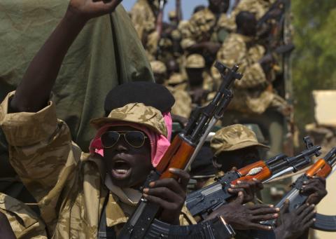 A SPLA soldier gestures as he sits in a vehicle in Juba