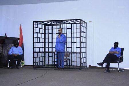 Saif al-Islam Gaddafi, son of late Libyan leader Muammar Gaddafi, is seen attends a hearing behind bars in a courtroom in Zintan, June 22, 2014 . REUTERS/Stringer