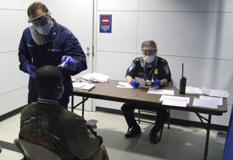 U.S. Coast Guard Health Technician Nathan Wallenmeyer (L) and Customs Border Protection (CBP) Supervisor Sam Ko conduct prescreening measures on a passenger arriving from Sierra Leone at O'Hare International Airport's Terminal 5 in Chicago, October 16, 2014.PHOTO BY REUTERS/U.S. Customs Border Protection