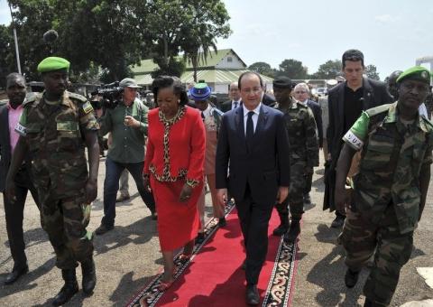 Central African Republic's interim President Catherine Samba-Panza (L) and French President Francois Hollande (R) walk together as he arrives at the presidential palace in Bangui