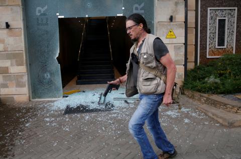 Serge Medic, the Swiss owner of a security company carries his pistol as he walks at the scene where explosions and gunshots were heard at the Dusit hotel complex in Nairobi, Kenya, January 15, 2019. PHOTO BY  REUTERS/Thomas Mukoya