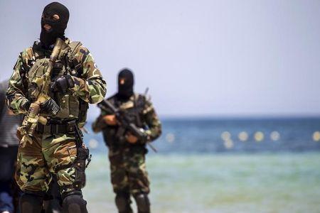 Tunisia's special forces secure the beachside of the Imperial Marhaba resort, while British, French, German and Tunisia's interior minister arrive to pay their tribute in front of a makeshift memorial in Sousse, Tunisia, June 29, 2015. PHOTO BY REUTERS/Zohra Bensemra