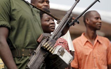 A military personnel carries his machine gun as he patrols past civilians following recent clashes against the decision made by Burundi's ruling CNDD-FDD party to allow President Pierre Nkurunziza to run for a third five-year term in office, in the capital Bujumbura, April 29, 2015. PHOTO BY REUTERS/Thomas Mukoya