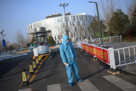 A security guard wearing a protective suit and a face mask stands as he holds a thermometer in front of the entrance to the China Transinfo Technology Co,in the morning after the extended Lunar New Year holiday caused by the novel coronavirus outbreak, in Zhongguancun Software Park, in Beijing, China, February 10, 2020. PHOTO BY REUTERS/Tingshu Wang