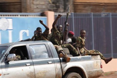 Seleka soldiers raise their fists while riding in a pick-up truck during fighting in Bangui, Central African Republic