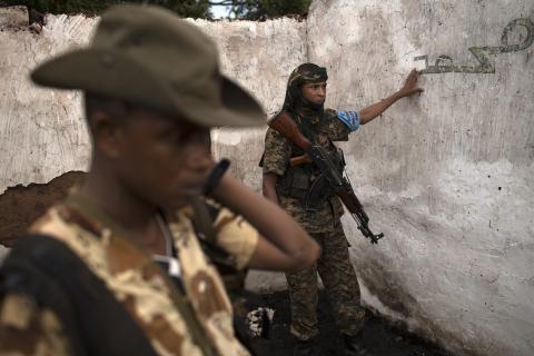 Former Seleka soldiers stand in the ruins of a mosque, which residents say was attacked and burnt the night before by anti-Balaka militiamen, about 25 kilometres (16 miles) from Bambari