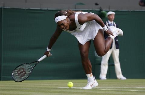 Serena Williams of the U.S. reacts as she fails to reach a shot during her women's singles tennis match against Alize Cornet of France at the Wimbledon Tennis Championships, in London