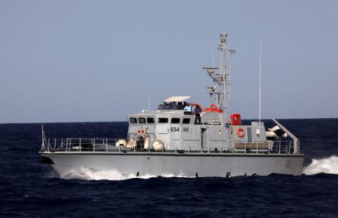 A Libyan coast guard vessel powers next to former fishing trawler Golf Azzurro of the Proactiva Open Arms rescue charity in the Western Mediterranean Sea, August 15, 2017. PHOTO BY REUTERS/Yannis Behrakis