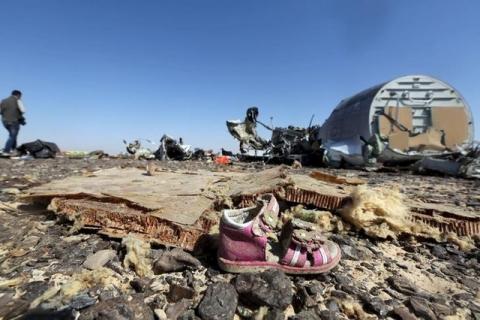 A child's shoe is seen in front of debris from a Russian airliner which crashed at the Hassana area in Arish city, north Egypt, November 1, 2015. PHOTO BY REUTERS/Mohamed Abd El Ghany