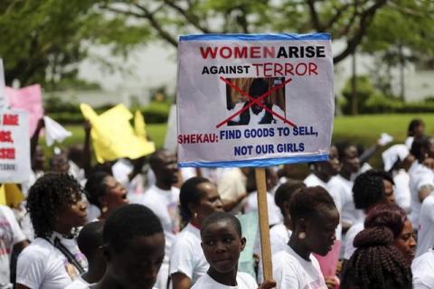 A student holds a sign with an image of Boko Haram leader?Abubakar?Shekau?as she protests for the release of the abducted secondary school girls in the remote village of Chibok, along a road in Lagos, May 12, 2014. PHOTO BY REUTERS/Akintunde Akinleye