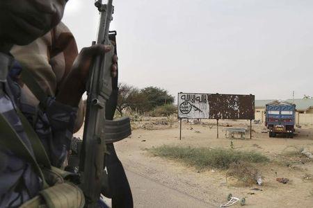 Chadian soldiers drive past a signpost painted by Boko Haram in the recently retaken town of Damasak, Nigeria, March 18, 2015. PHOTO BY REUTERS/Emmanuel Braun