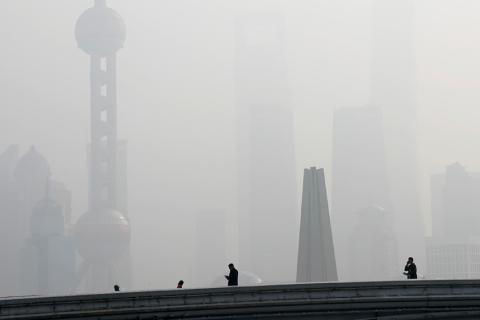 People walk on a bridge in front of the financial district of Pudong, which is covered in smog, during a polluted day in Shanghai, China, November 28, 2018. PHOTO BY REUTERS/Aly Song