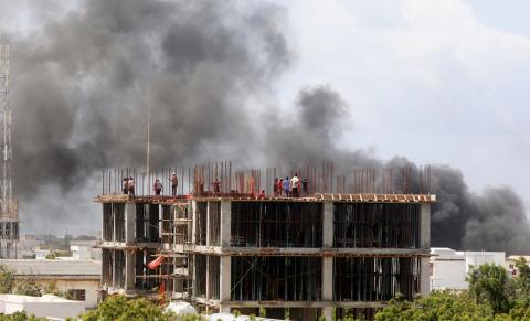 Workers are seen on a construction site as smoke billows from the scene of an explosion in Mogadishu, Somalia, July 22, 2019. PHOTO BY REUTERS/Feisal Omar