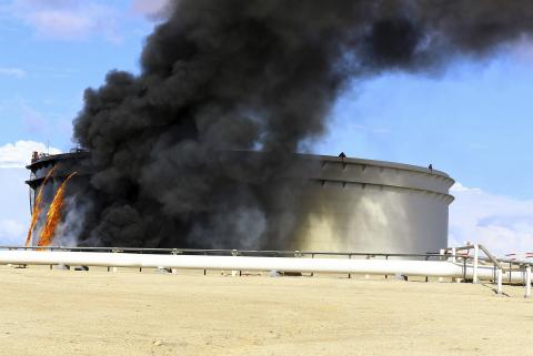 Black smoke billows out of a storage oil tank in the port of Es Sider in Ras Lanuf, December 25, 2014. PHOTO BY REUTERS/Stringer