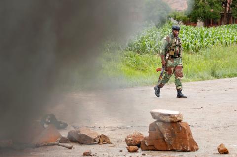 A soldier walks past a burning barricade in Harare, Zimbabwe, January 15, 2019. PHOTO BY REUTERS/Philimon Bulawayo