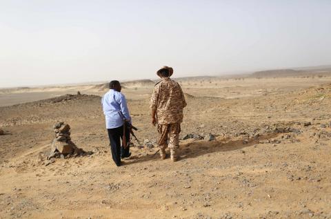 A Libyan soldier (R) and a member of a security unit patrol the desert border between Libya and Algeria