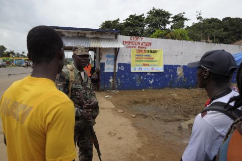 Liberian soldiers (C) check people travelling in Bomi County