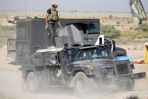 A member of the Iraqi security forces ride atop a military vehicle near Falluja, Iraq, May 31, 2016. PHOTO BY REUTERS/Thaier Al-Sudani