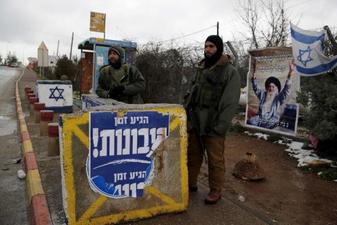 Israeli soldiers stand next to a concrete barrier as they guard near a bus stop in the Gush Eztion Jewish settlement bloc in the West Bank, January 27, 2016. PHOTO BY REUTERS/Amir Cohen