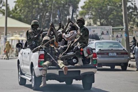 Soldiers and people carrying machetes ride on the back of a vehicle along a street in Gombe , Nigeria, January 30, 2015. PHOTO BY REUTERS/Afolabi Sotunde