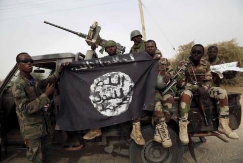 Nigerian soldiers hold up a Boko Haram flag that they had seized in the recently retaken town of Damasak, Nigeria, March 18, 2015. PHOTO BY REUTERS/Emmanuel Braun