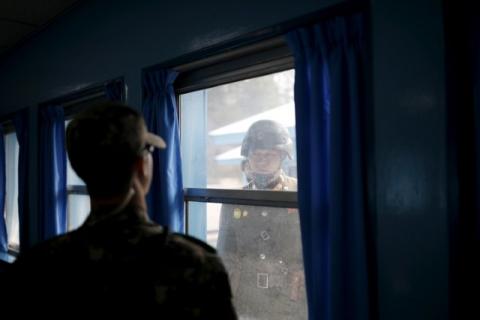 North (R) and South Korean soldiers look at each other through a window of a conference room in the United Nations Command Military Armistice Commission Conference Building at the truce village of Panmunjom, South Korea, March 30, 2016. PHOTO BY REUTERS/Kim Hong-Ji