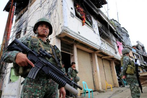 Government soldiers stand guard in front of damaged building and houses in Sultan Omar Dianalan boulevard at Mapandi district in Marawi city, southern Philippines, September 13, 2017. PHOTO BY REUTERS/Romeo Ranoco