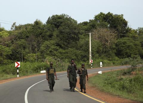 Members of the Sri Lankan army walk along a newly constructed road in Mullaitivu district June 7, 2014. PHOTO BY REUTERS/Nita Bhalla