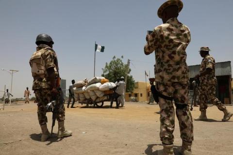 Men push a cart loaded with goods past soldiers at the boarder in Gamboru Ngala, Borno, Nigeria, April 27, 2017. PHOTO BY REUTERS/Afolabi Sotunde