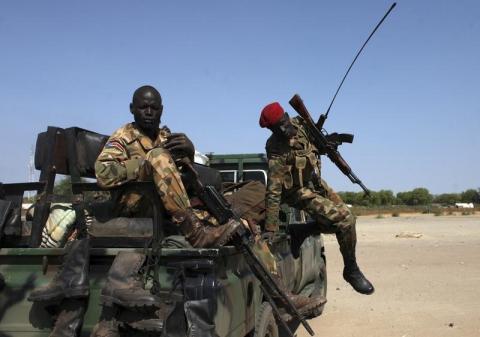 An SPLA soldier jumps off of a pick-up truck in Bentiu, Unity state