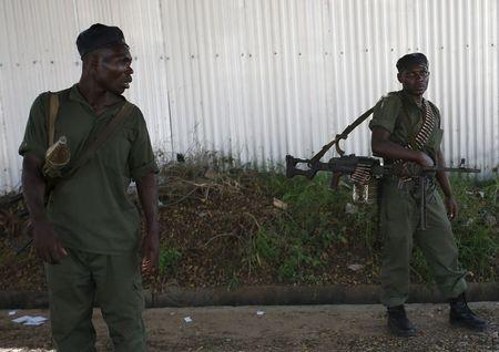 Soldiers, loyal to President Pierre Nkurunziza, hold weapons near the body of a soldier (not in picture), loyal to the coup leader, at a street in Bujumbura, Burundi, May 14, 2015. PHOTO BY REUTERS/Goran Tomasevic