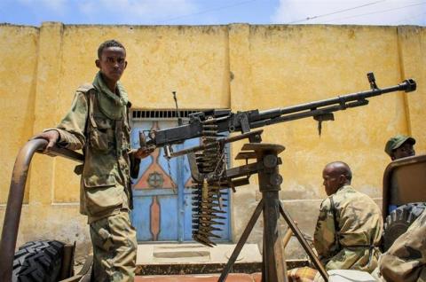 A fighter of the pro-government Ras Kimboni Brigade mans a heavy machine gun mounted at the back of a pick-up truck while parked along the roadside in the centre of the southern Somali port city of Kismayo