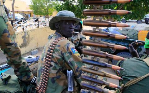 A South Sudan army soldier stands next to a machine gun mounted on a truck in Malakal town, 497km (308 miles) northeast of capital Juba, December 30, 2013 a few days after retaking the town from rebel fighters