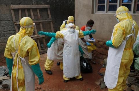 Healthcare workers disinfect gear during a funeral of Kavugho Cindi Dorcas who is suspected of dying of Ebola in Beni, North Kivu Province of Democratic Republic of Congo, December 9, 2018. PHOTO BY REUTERS/Goran Tomasevic