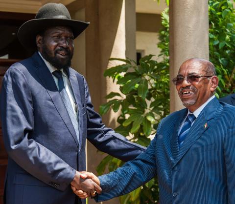 Sudan's President Omar al-Bashir (R) shakes hands with his host, South Sudan's President Salva Kiir, at Juba Airport