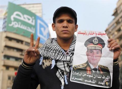 A supporter of Egypt's army chief and defense minister General Abdel Fattah al-Sisi holds a poster with Sisi's image during a protest in support of the new constitution at Tahrir Square in Cairo