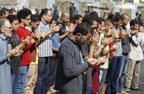 Supporters of the Muslim Brotherhood and ousted Egyptian President Mohamed Mursi pray outside the police academy