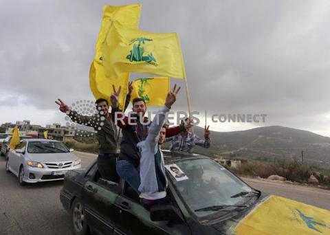 Supporters of Lebanon's Hezbollah leader Sayyed Hassan Nasrallah gesture as they hold Hezbollah flags in Marjayoun, Lebanon May 7, 2018. PHOTO BY REUTERS/Aziz Taher