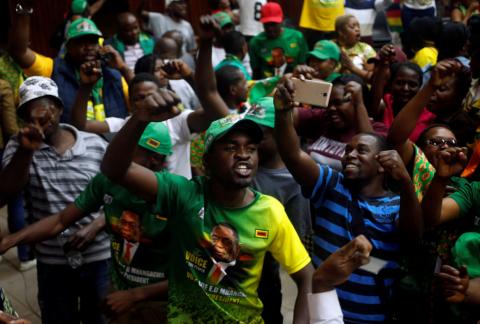 Supporters of President Emmerson Mnangagwa's ruling ZANU-PF party react to the results of a constitutional court hearing challenging his electoral victory in Harare, Zimbabwe, August 24, 2018. PHOTO BY REUTERS/Philimon Bulaway